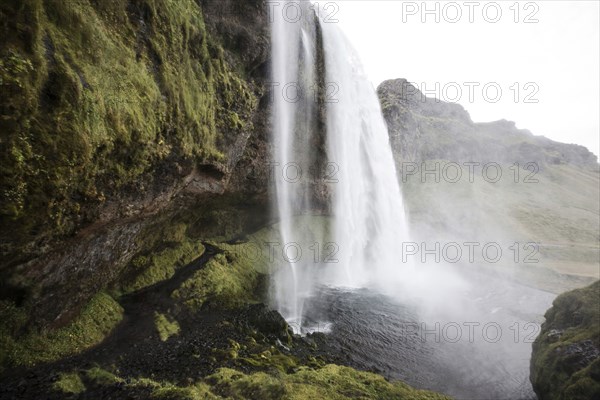 Waterfall over rock formation cliffs