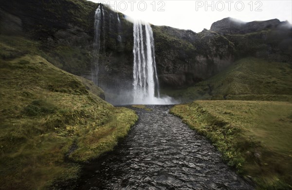 Waterfall pouring over rocky cliff