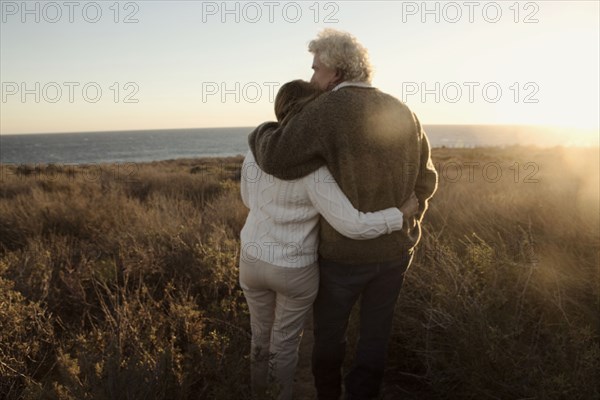 Older Caucasian couple looking at ocean view