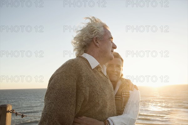 Older Caucasian couple hugging outdoors