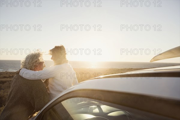 Older Caucasian couple hugging outdoors