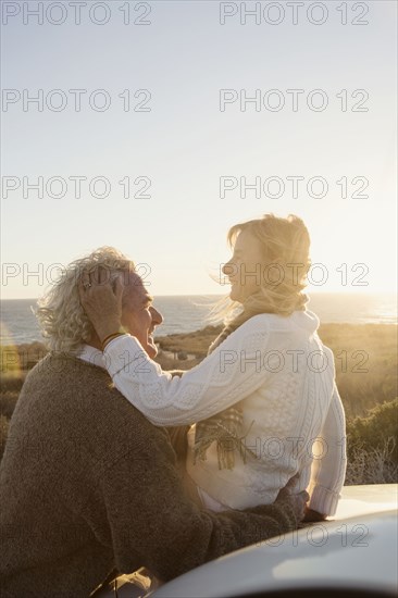 Older Caucasian couple hugging outdoors