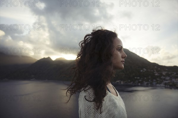 Wind blowing hair of Mixed Race woman near lake