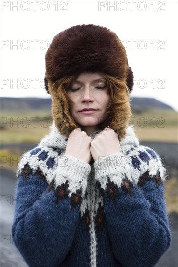 Caucasian woman wearing sweater and fur hat