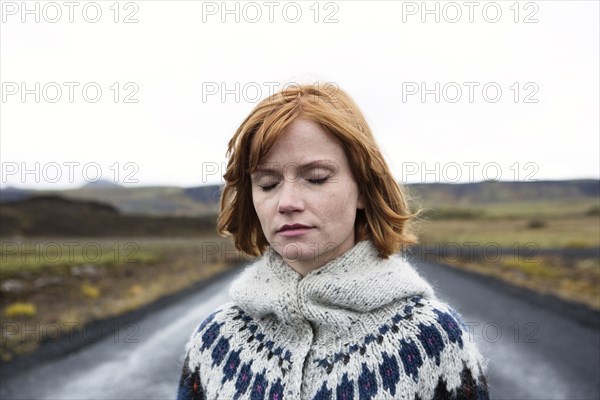 Caucasian woman wearing sweater in road