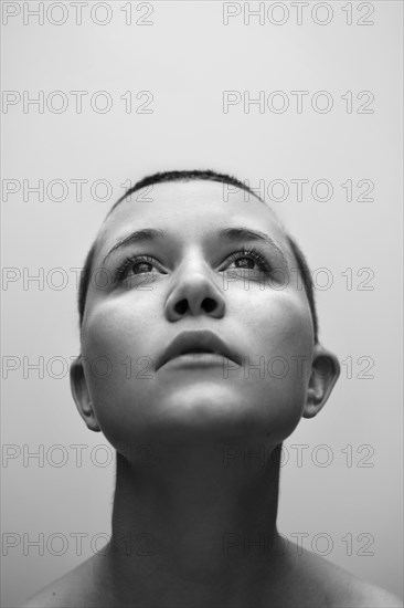 Caucasian woman with shaved-head looking up