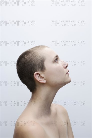 Caucasian woman with shaved-head looking up