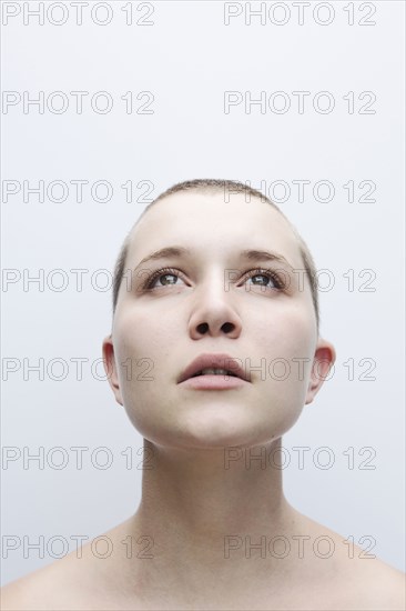 Caucasian woman with shaved-head looking up