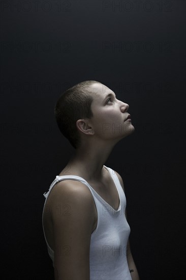 Caucasian woman with shaved-head looking up