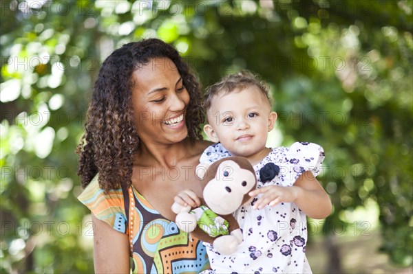 Mother holding toddler outdoors