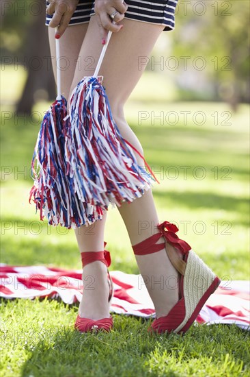 Caucasian woman in heels holding pom-poms