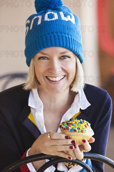 Caucasian woman eating cupcake