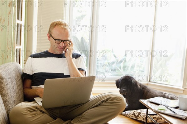 Caucasian man using laptop on sofa