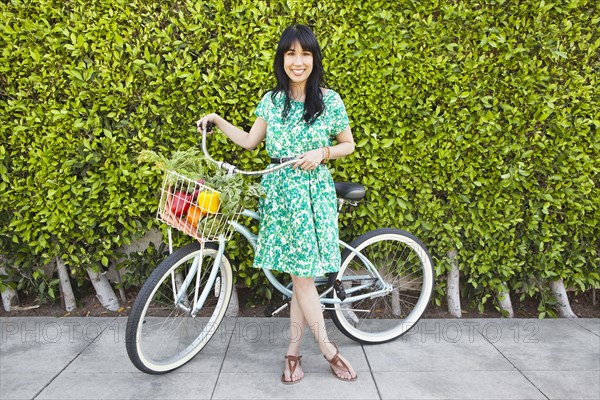 Woman carrying produce in bicycle basket