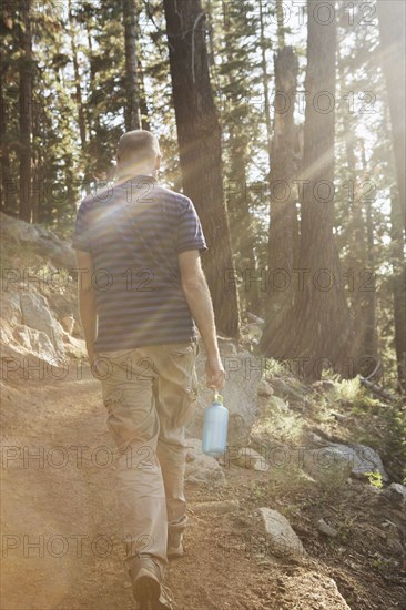 Man hiking on dirt trail in forest