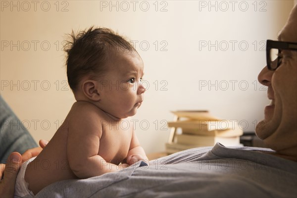 Smiling father playing with baby