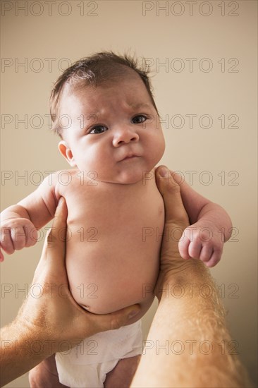 Low angle view of father lifting baby