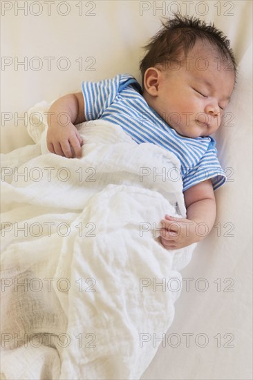 Mixed race baby sleeping in bed