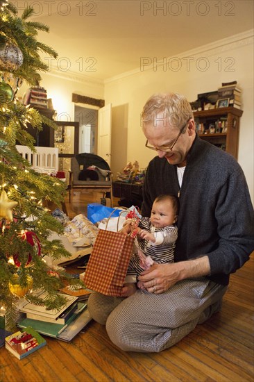 Father and baby boy opening Christmas gifts