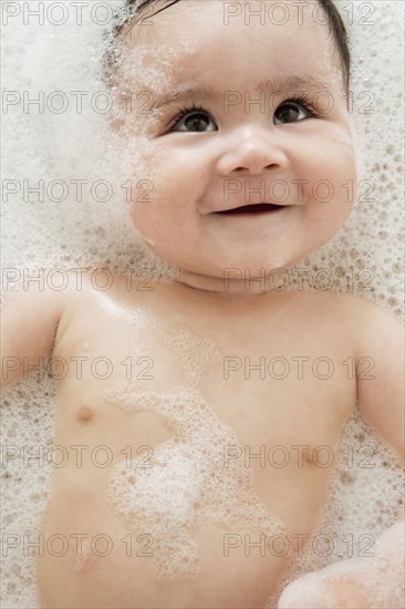Close up of mixed race baby in bubble bath