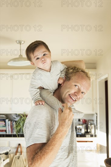 Father carrying baby son on shoulders