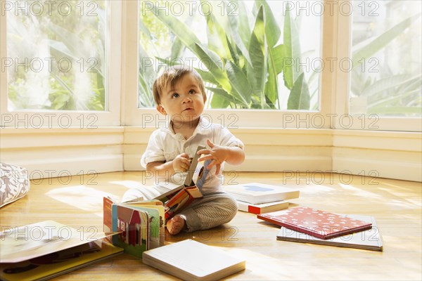 Mixed race baby boy playing on floor