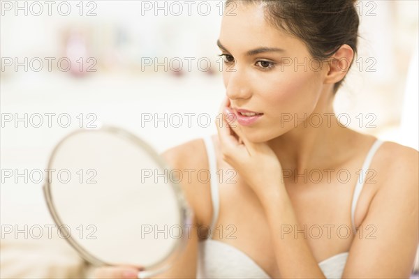 Caucasian woman admiring herself in mirror