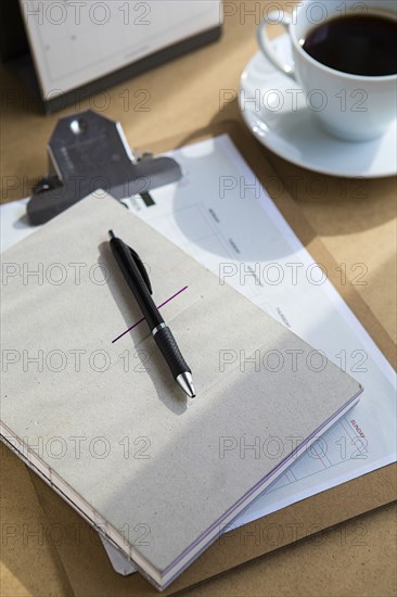 Tablet computer on table with books and cup of coffee