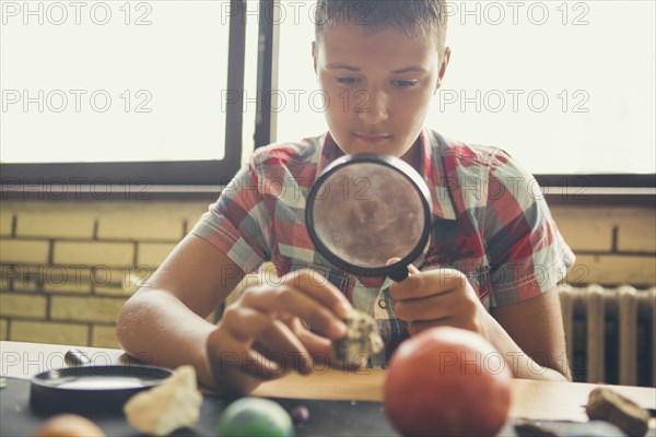 Student examining models of planets in classroom