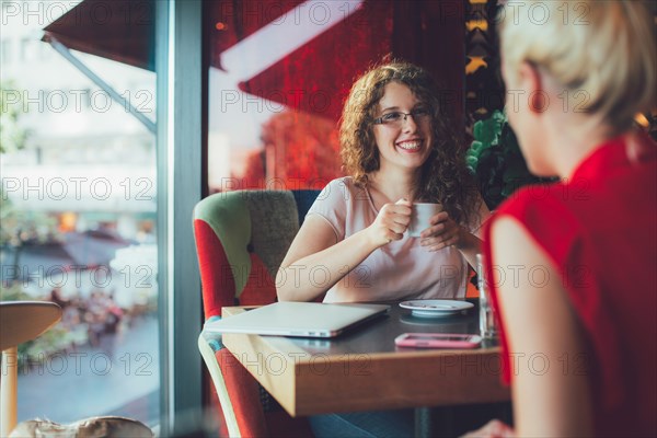 Women drinking coffee together in cafe