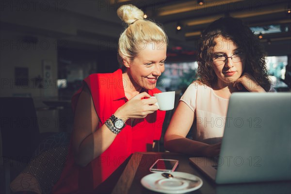 Women using laptop computer in cafe