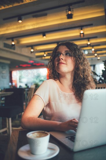 Woman using laptop computer in cafe