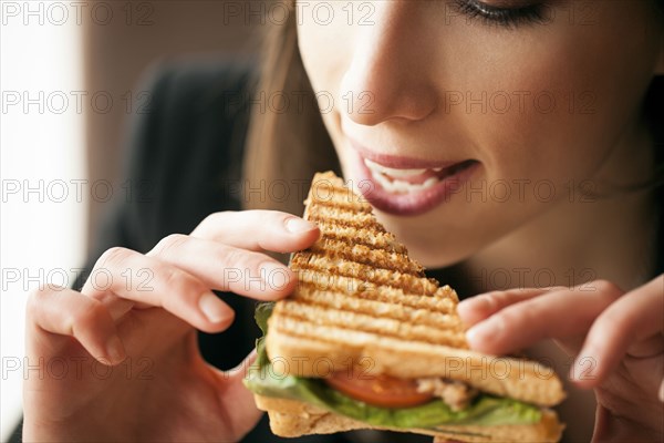 Close up of woman eating sandwich