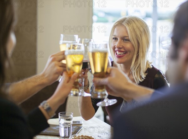 Friends toasting with beer in cafe