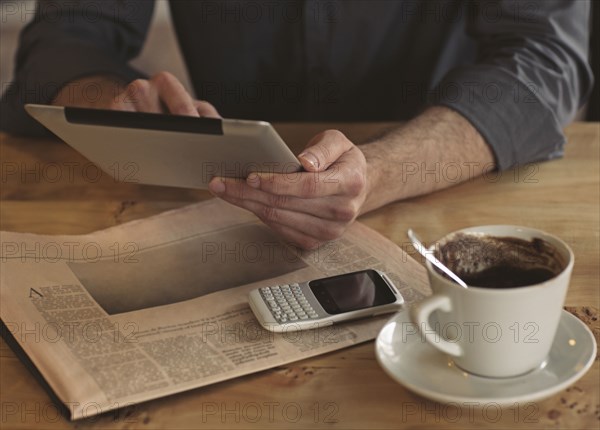 Man using digital tablet with cup of coffee