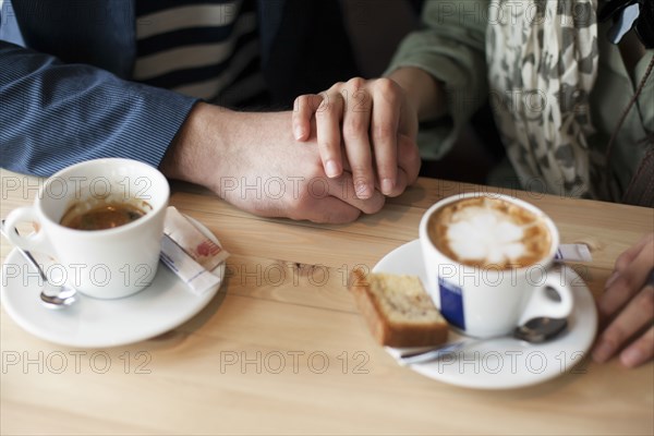 Couple holding hands in cafe