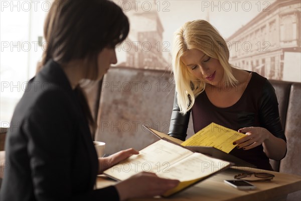 Women reading menus in cafe