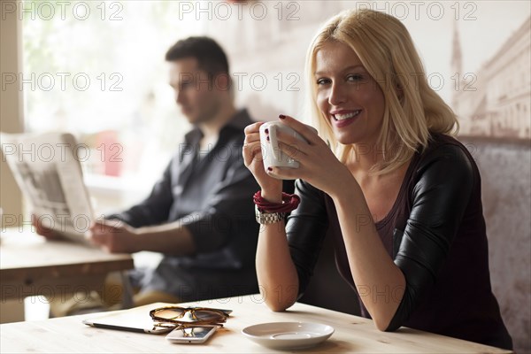 Woman drinking cup of coffee in cafe