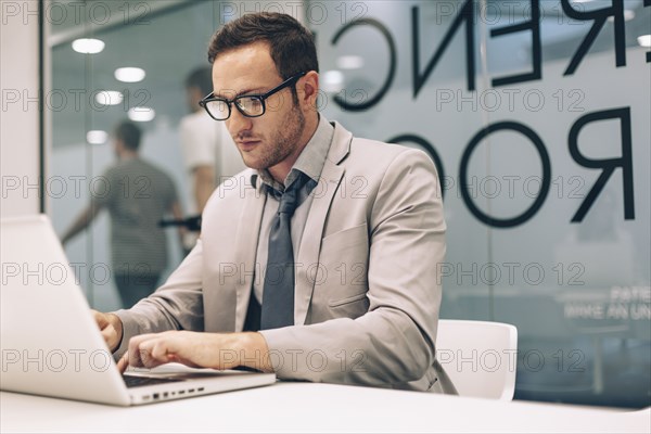 Caucasian businessman working on laptop in office