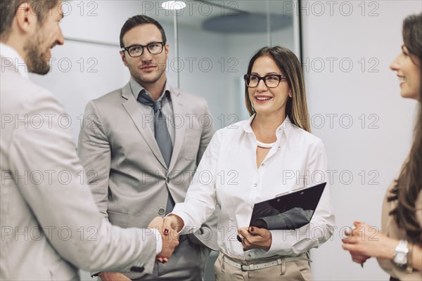 Caucasian business people shaking hands in office