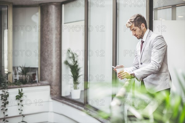 Caucasian businessman using cell phone on office balcony