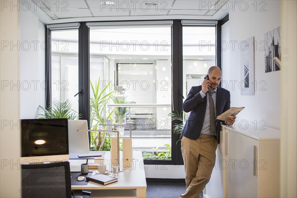 Caucasian businessman talking on cell phone in office