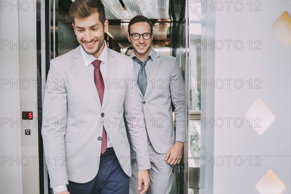 Caucasian businessmen walking out of elevator