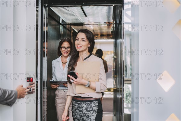 Caucasian businesswomen walking out of elevator