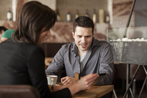 Couple using cell phone in cafe