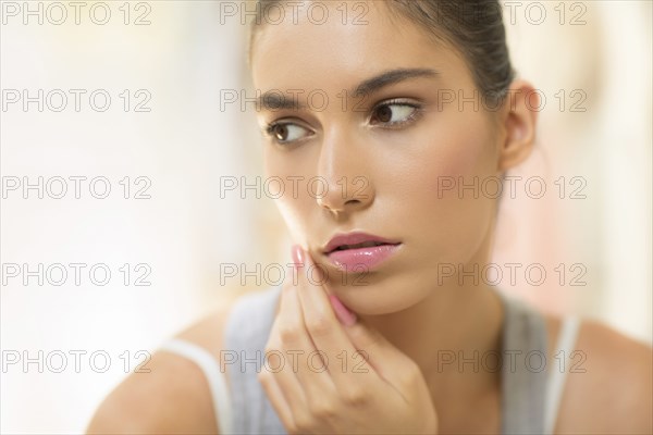 Close up of pensive woman touching cheek