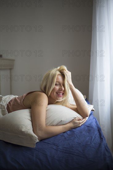 Smiling woman laying in bed