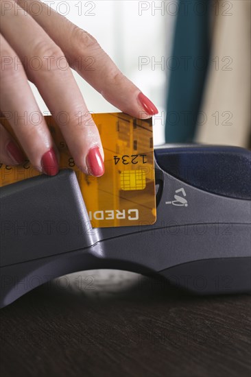 Close up of woman swiping credit card in credit card reader
