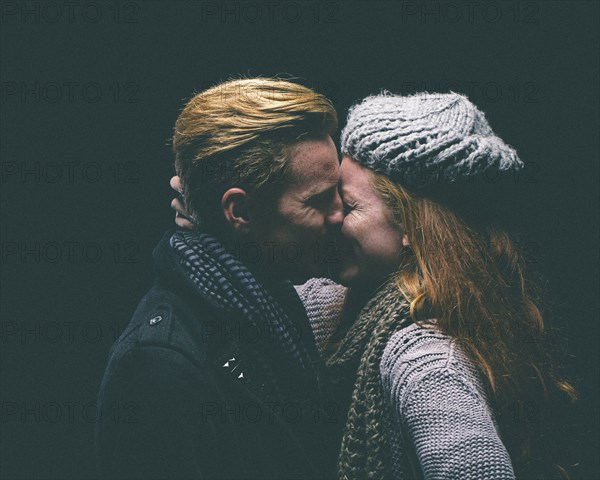 Couple wearing warm clothing kissing