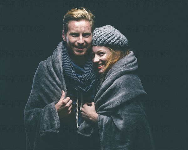 Smiling couple wrapped in blanket